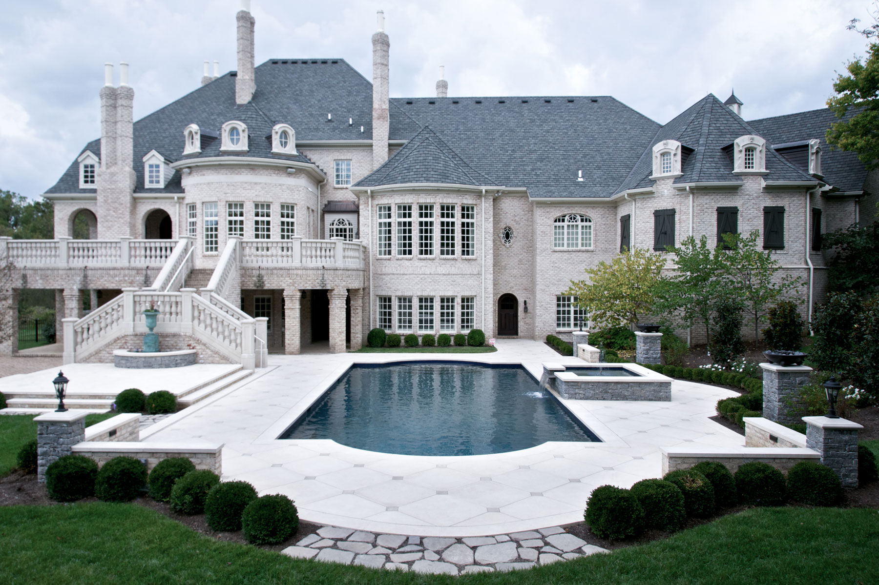 This palatial estate, with its extensive pool patio space, has stark pool coping pavers
