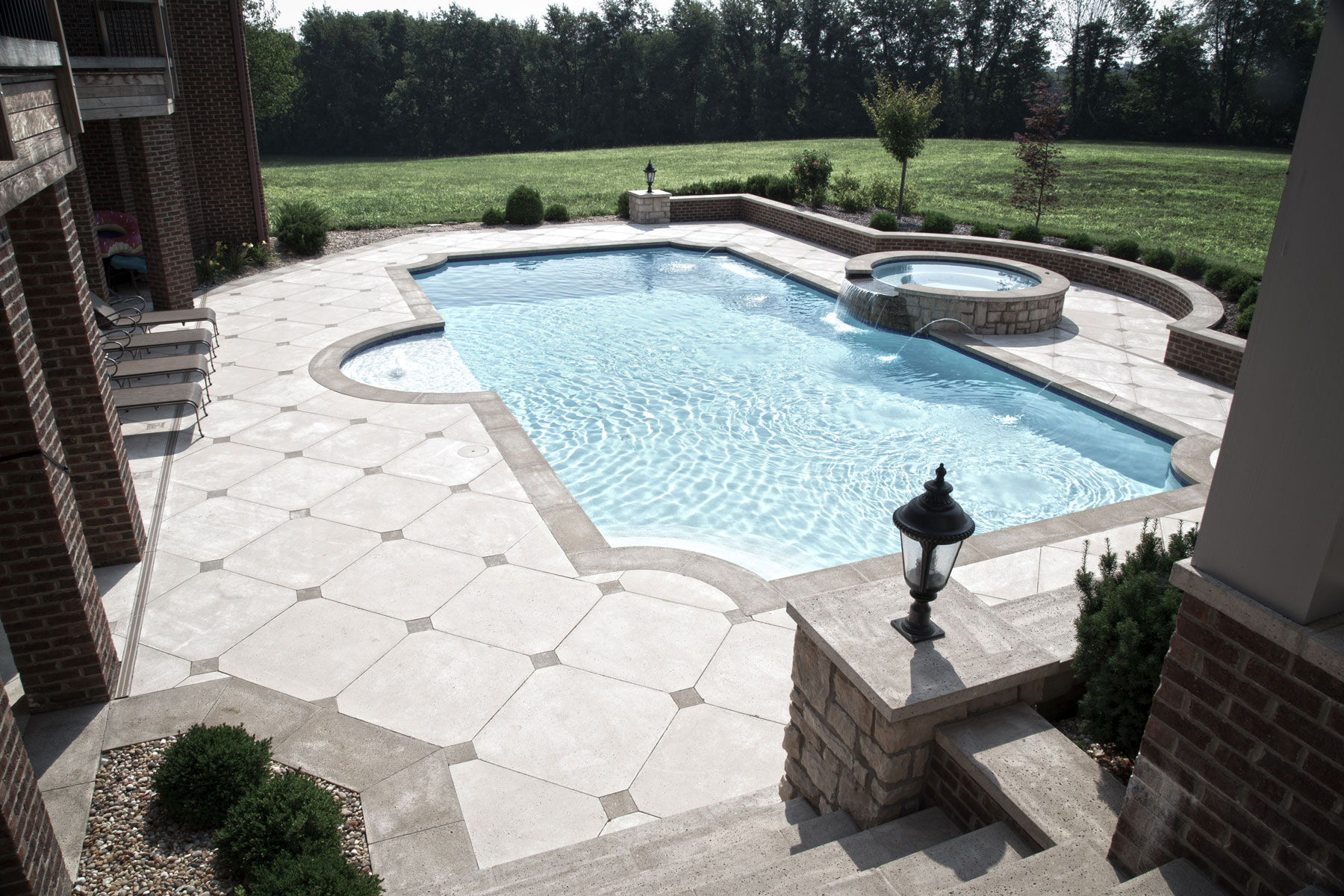 The pool coping tiles follow the unique shape of the water feature, offset by the rectangle deck pavers