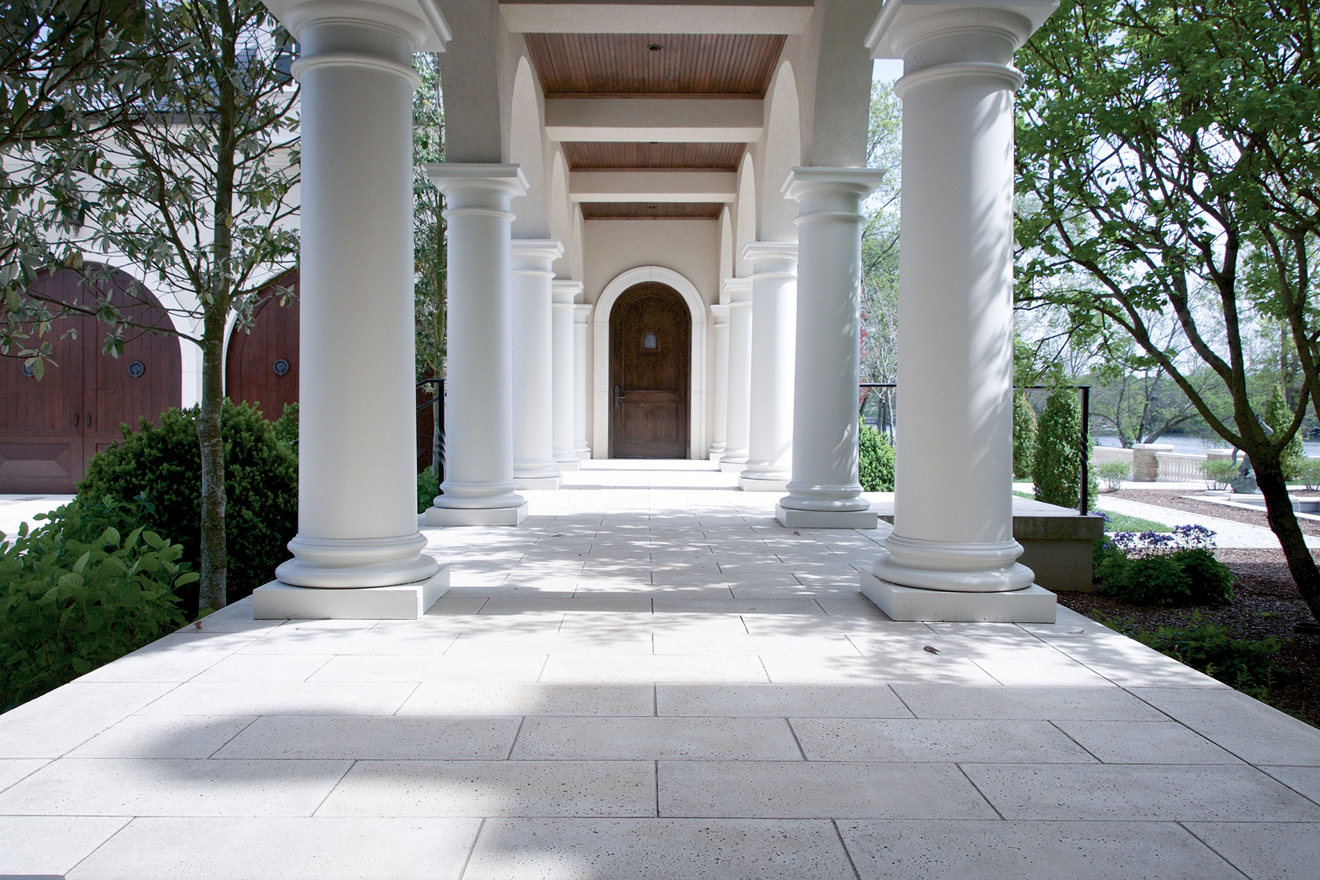 This covered walkway has custom door surrounds, deck columns, and slab steps that raise the walkway floor level