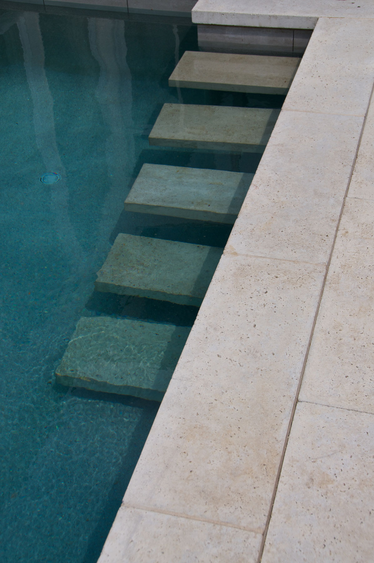 The inground pool steps are a similar material to the coping pavers