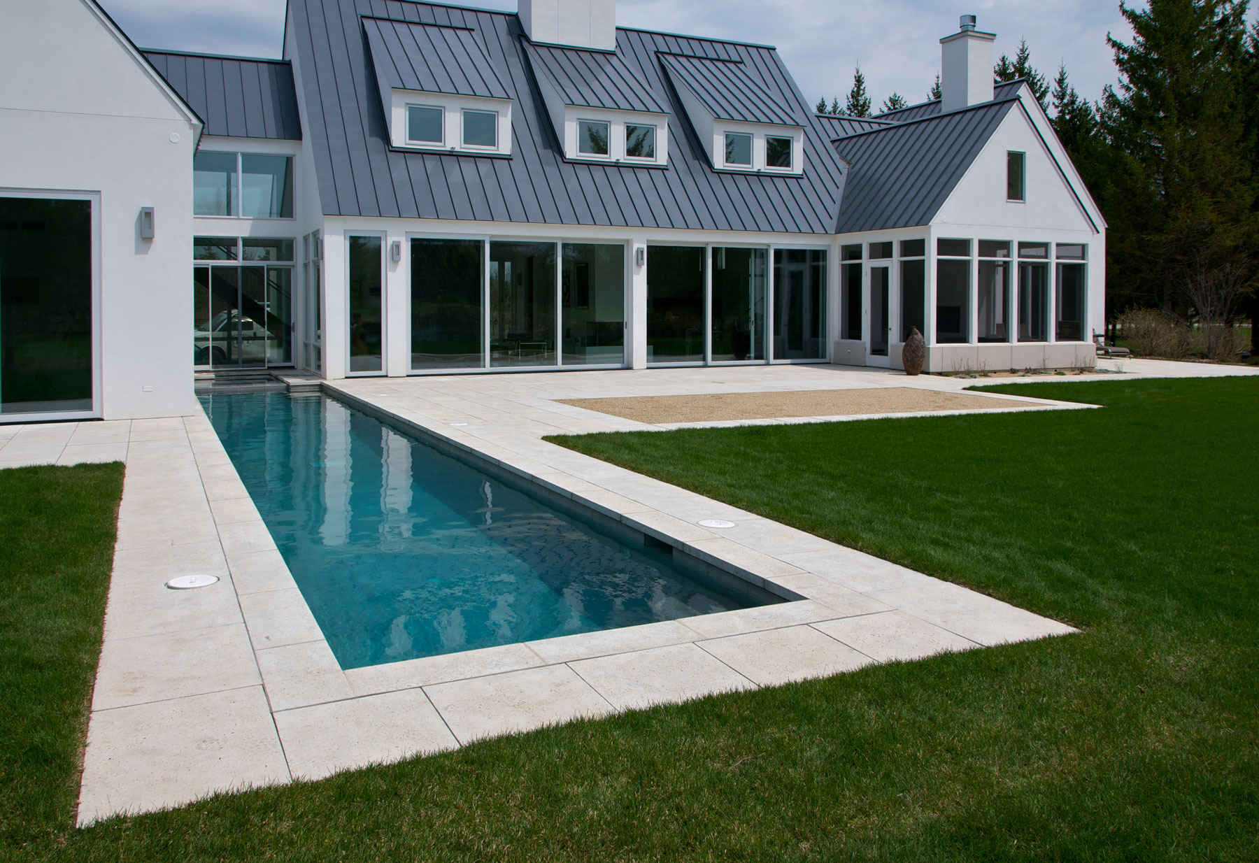 This modern pool deck hardscape features custom pool pavers and deck pavers