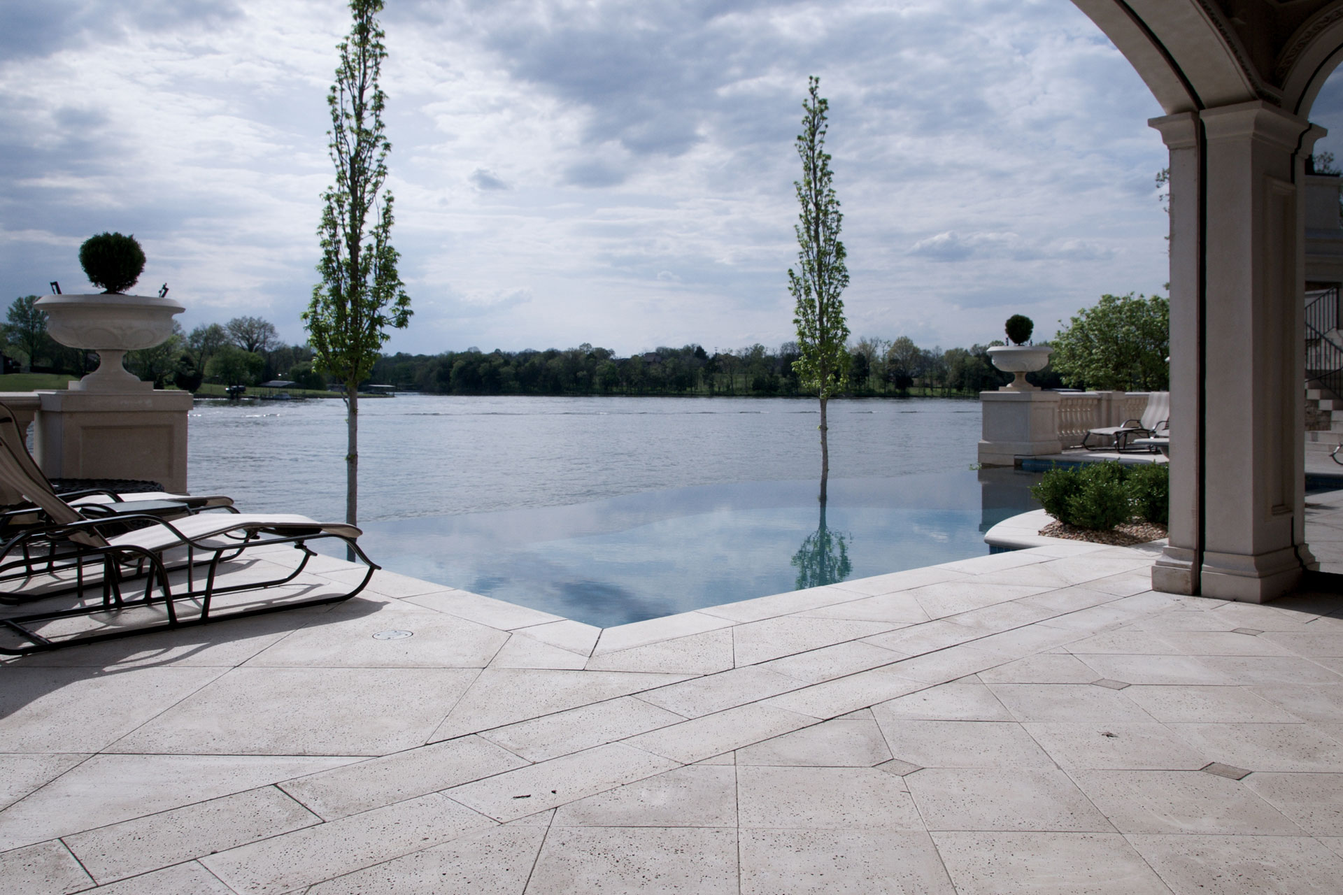 The pool deck pavers and other pavers around pool also extend to the natural lakeside
