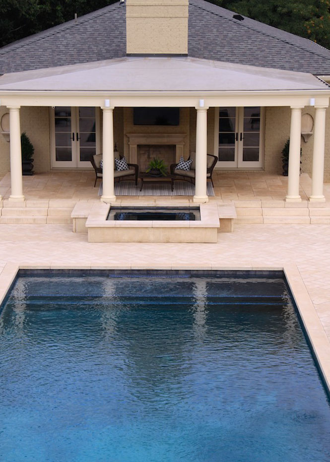 The pool coping tiles are also found on a nearby water feature, and match the pavers around pool radius