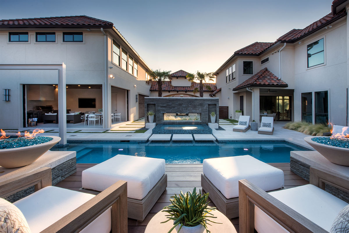 This backyard oasis with pool deck pavers is elegant and relaxing