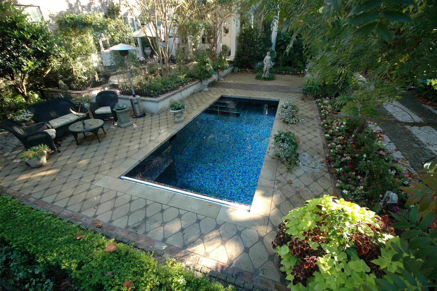 The pool deck design features custom concrete diamond pavers