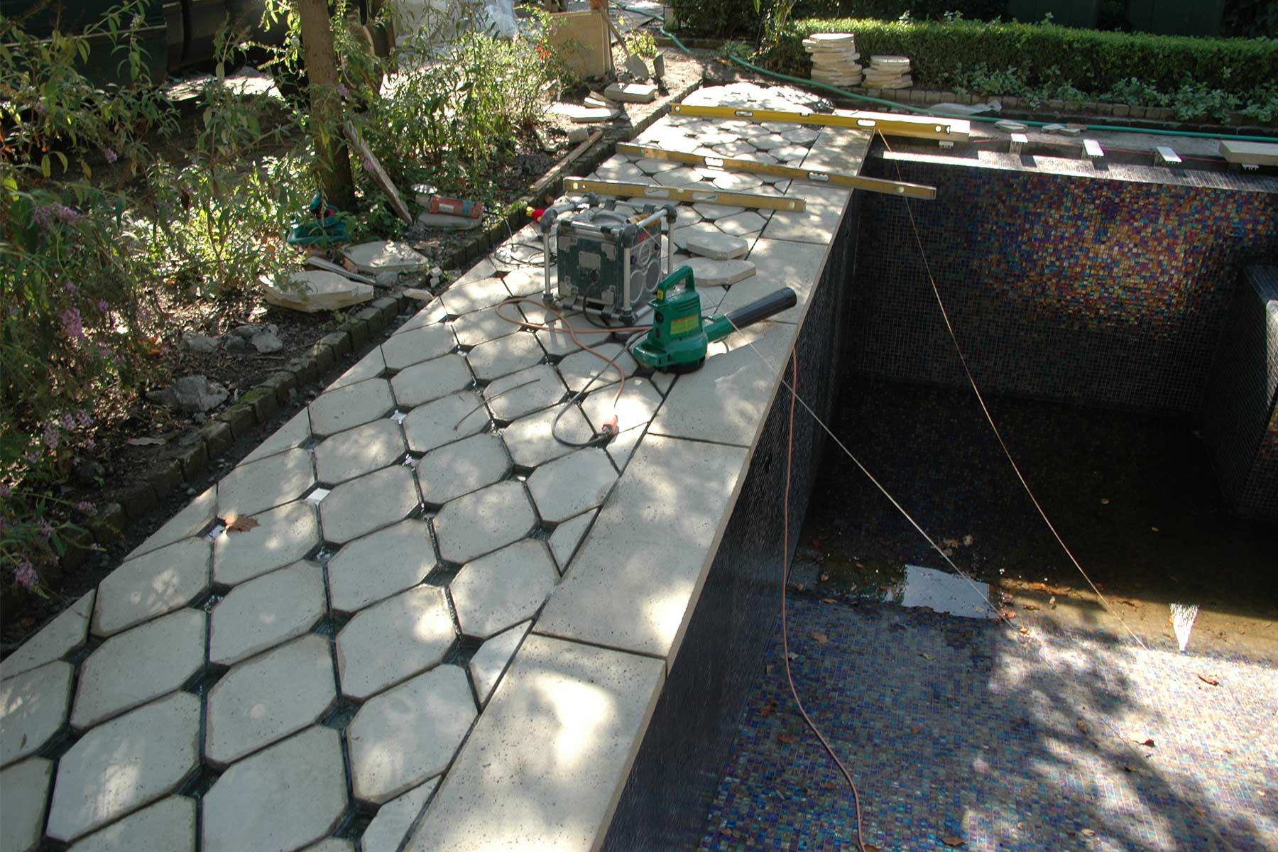 A close-up look at pool coping tiles and concrete pavers around pool